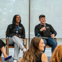 President Mantella sitting on chair on stage with three other panelists
